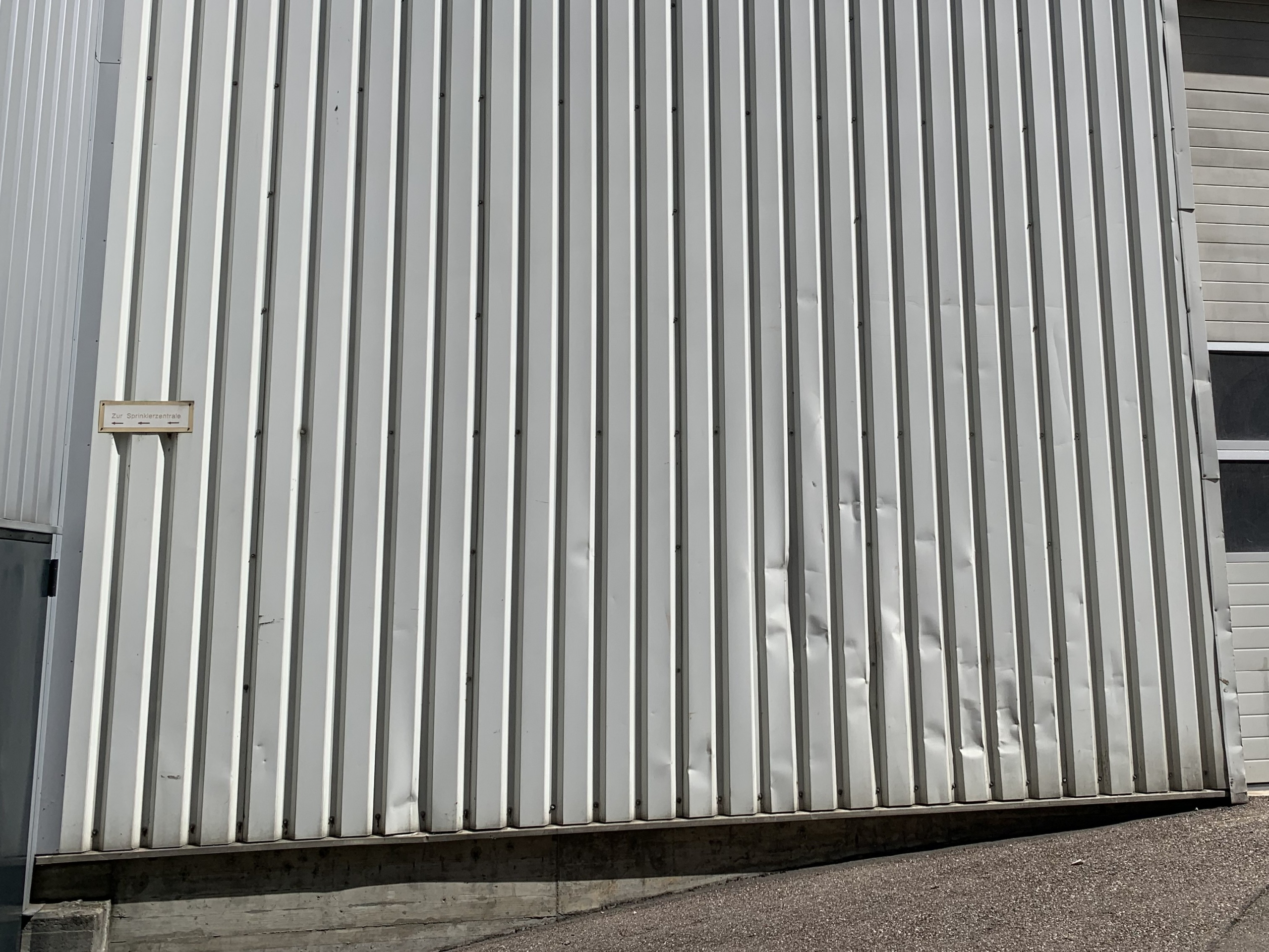 Industriehalle mit sichtbaren Verformungen nach Unwetter