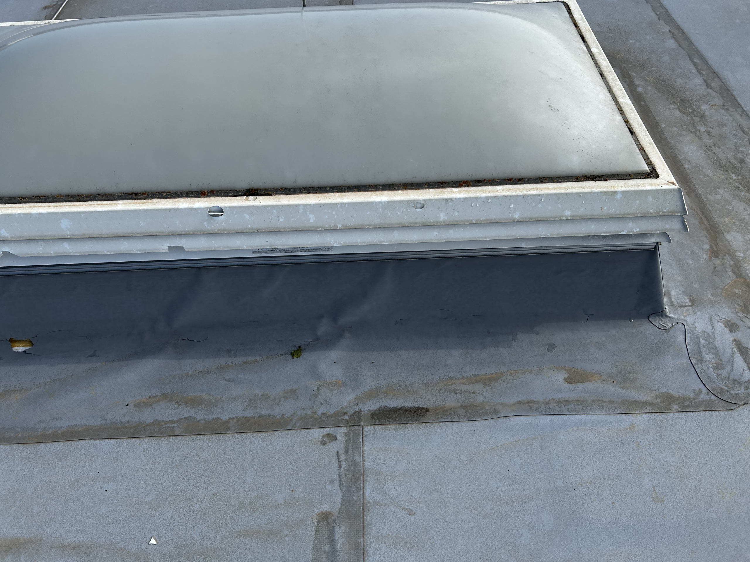 Beschädigte Lichtkuppel auf Flachdach durch Hagel mit sichtbaren Einschlägen